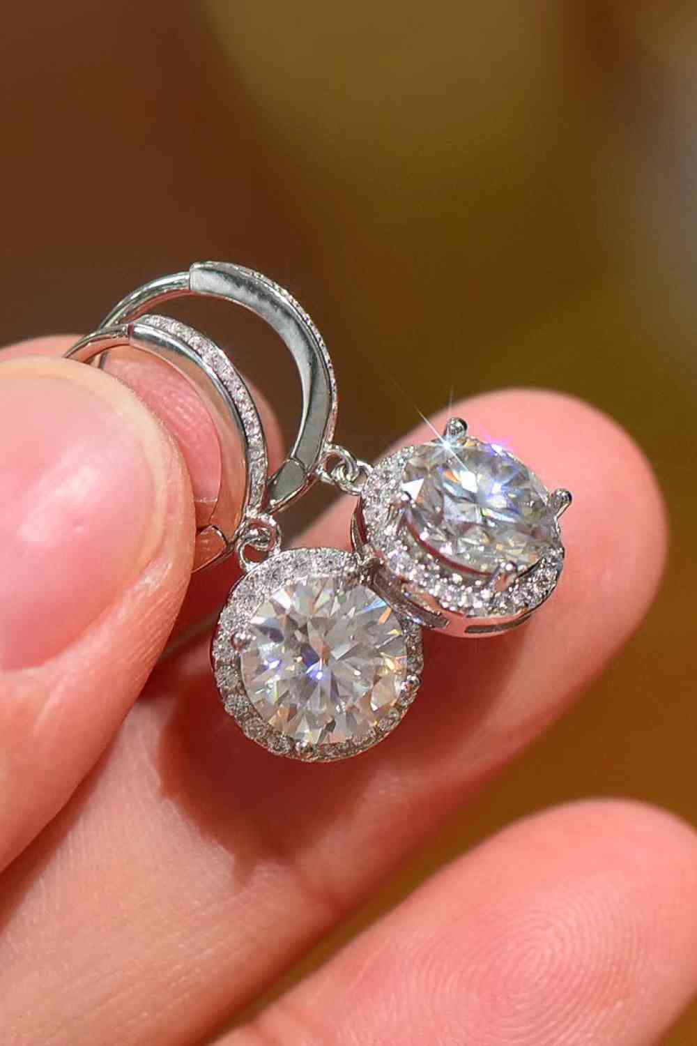 a close up of a person holding a pair of earrings