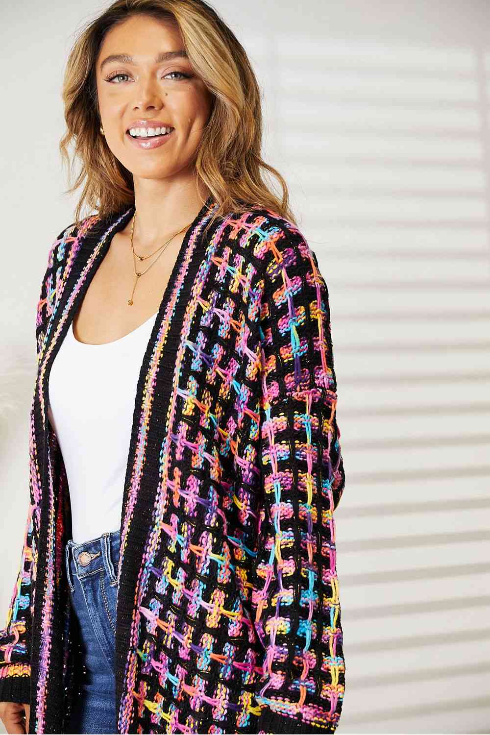 a woman wearing a black and multi colored cardigan