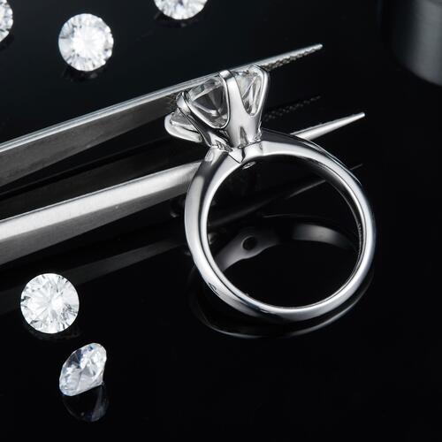 a diamond ring sitting on top of a table next to a pair of scissors